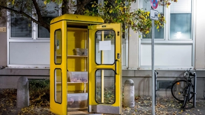 Eine „Foodsharing“-Station in einer gelben Telefonzelle ist mit Brötchen und Borten befüllt. (Foto: Daniel Vogl/dpa)
