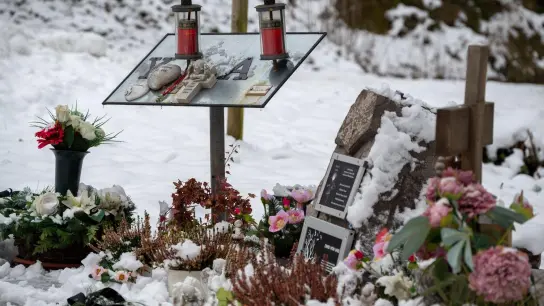Ein Gedenkstein, eine Gedenktafel, Engelfiguren und Blumen erinnern auf einem Parkplatz bei Kusel an die beiden Polizisten, die vor einem Jahr im Dienst getötet wurden. (Foto: Harald Tittel/dpa)