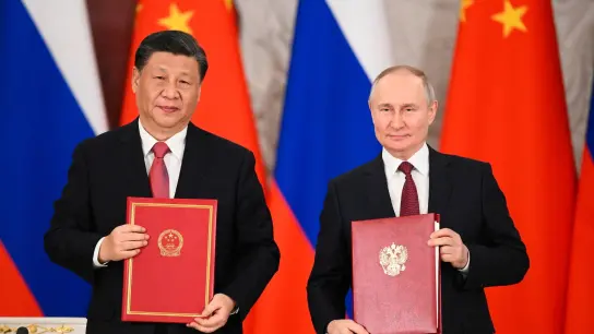 Chinas Präsident Xi Jinping und sein russischer Amtskollege Wladimir Putin zeigen während einer Unterzeichnungszeremonie Mappen mit den neuen Abkommen. (Foto: Vladimir Astapkovich/Sputnik Kremlin Pool via AP/dpa)