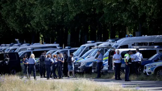 Einsatzkräfte der Polizei warten auf der Theresienwiese auf den Beginn einer Großdemonstration. (Foto: Daniel Karmann/dpa)