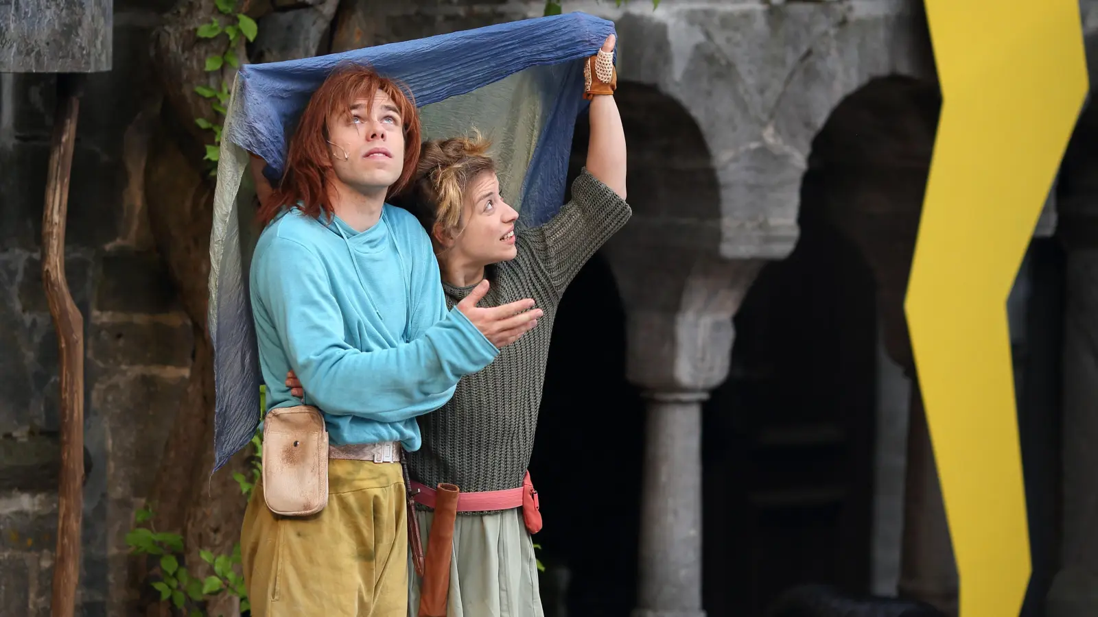 Suchen zusammen Schutz vor dem Regen: Constantin Petry als Birk Borkasohn und Juliane Krug als Ronja Räubertochter. (Foto: Thomas Wirth)