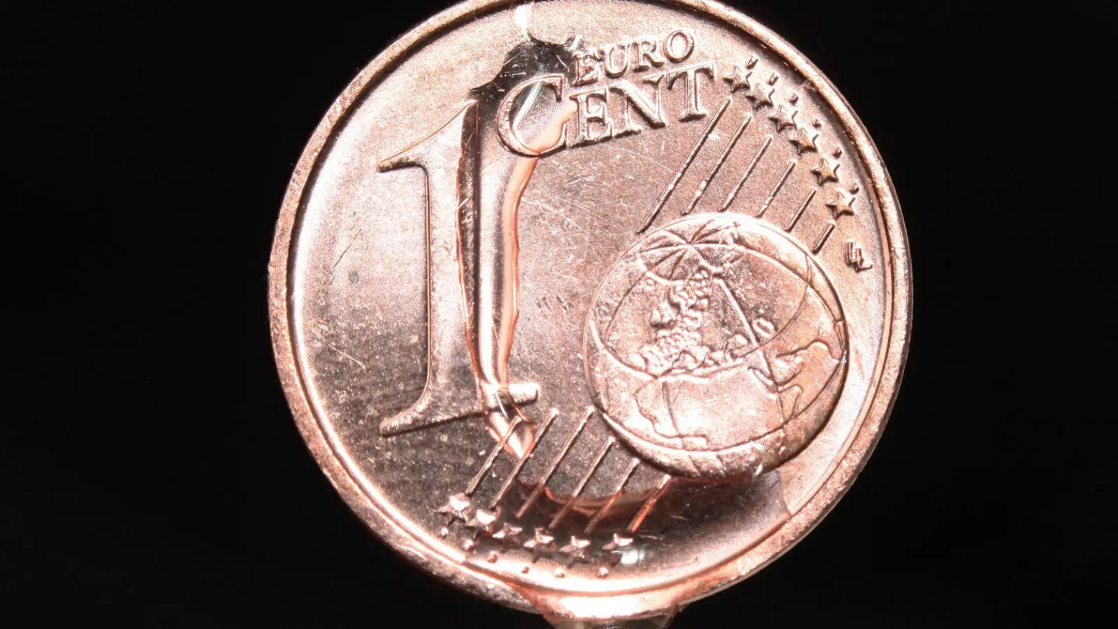Wasser tropft von einer Ein-Cent-Münze. (Foto: Fredrik von Erichsen/dpa/Archivbild)