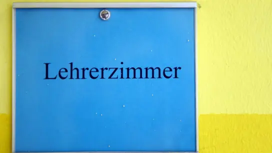 „Lehrerzimmer“ steht auf einem Schild in einer Grundschule. In Nordrhein-Westfalen sind nach einer jüngsten Statistik rund 8000 Lehrerstellen nicht besetzt. Auch in anderen Bundesländern fehlen Lehrer. (Foto: Caroline Seidel/dpa)