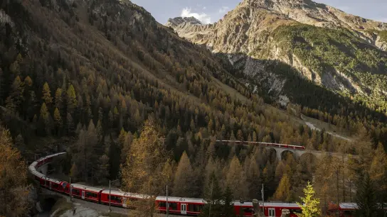 Ein mit fast zwei Kilometern außergewöhnlich langer Reisezug der Rhätischen Bahn (RHB) fährt durch Graubünden. (Foto: Gian Ehrenzeller/KEYSTONE/dpa)