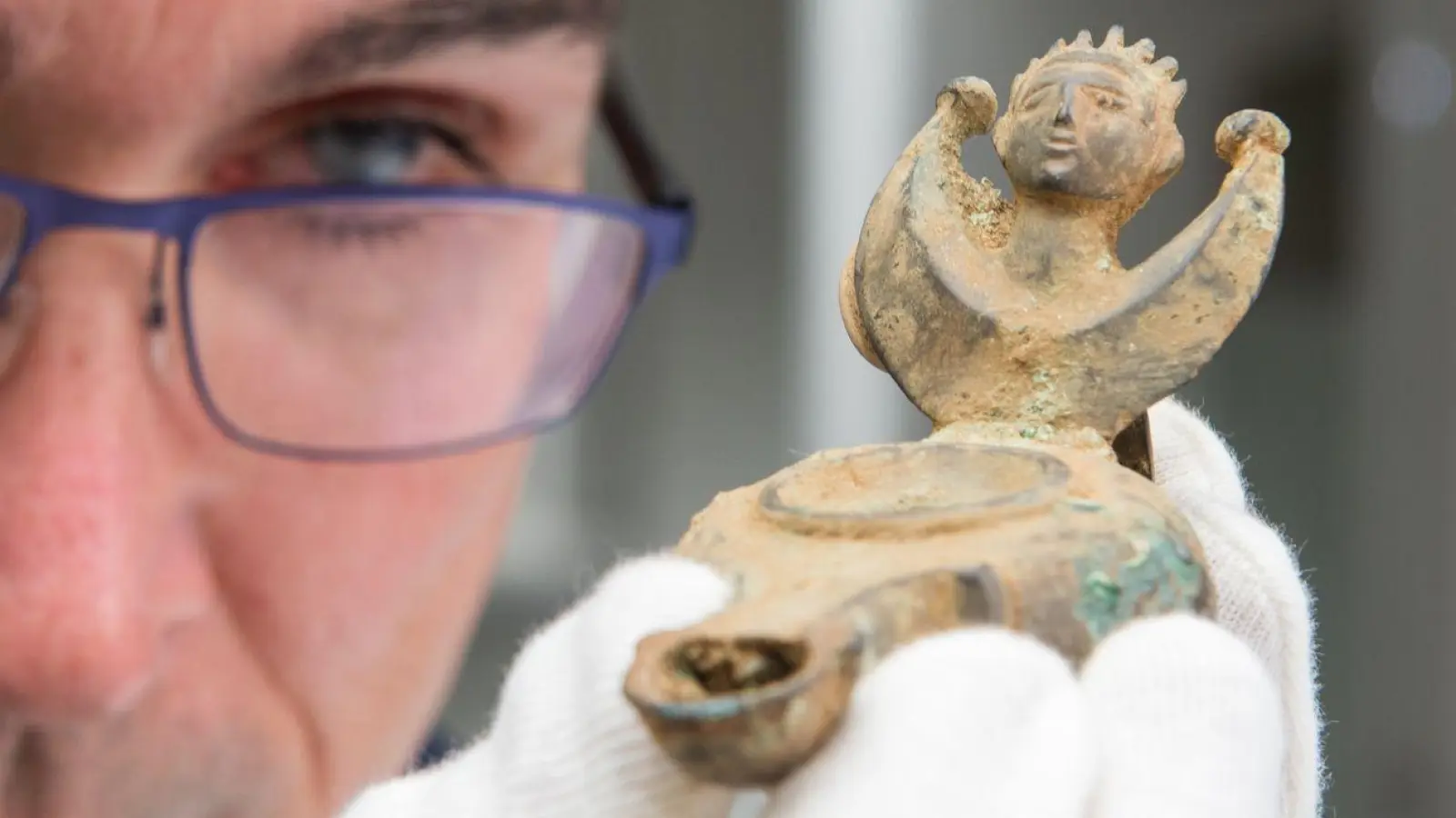 Augsburgs Stadtarchäologe Sebastian Gairhos betrachtet eine antike Öllampe, die vor wenigen Jahren in Bayerns ältestem Römerlager entdeckt wurde. (Archivbild) (Foto: Stefan Puchner/dpa)