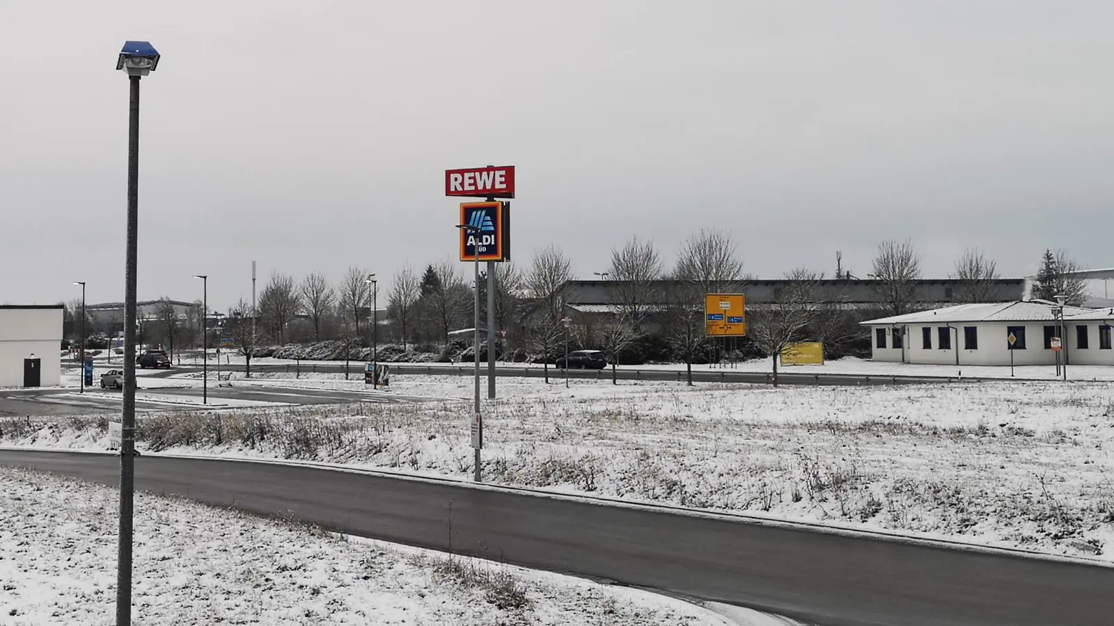 Realisiert werden soll der Servicepark auf der unweit der A7-Anschlussstelle gelegenen Fläche rechts, in direkter Nachbarschaft zweier Lebensmittelmärkte. E-Auto-Besitzer könnten die Ladezeit somit auch für Einkäufe nutzen. (Foto: Jürgen Binder)