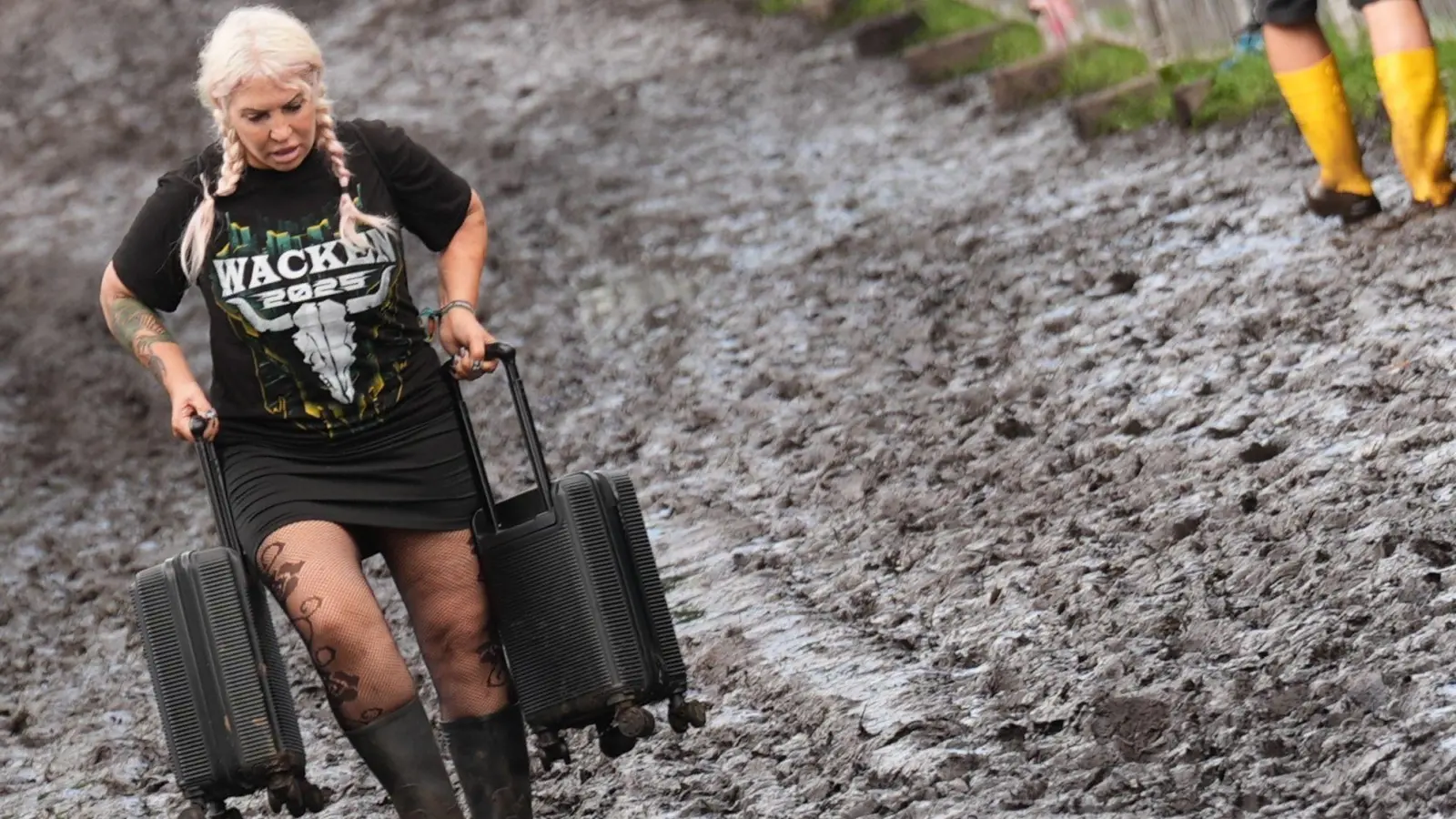 Nicht alle Besucherinnen und Besucher sind auf den Schlamm vorbereitet. (Foto: Marcus Brandt/dpa)