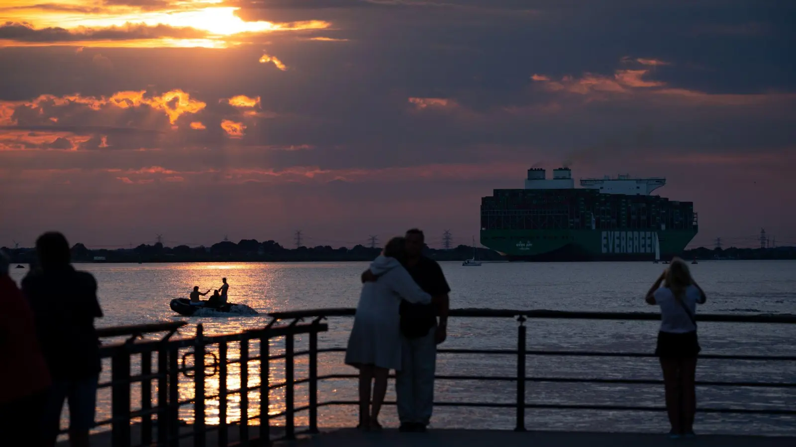 Romantische Aussichten: Ausflügler beobachten den Sonnenuntergang an der Elbe in Wedel. (Foto: Jonas Walzberg/dpa)