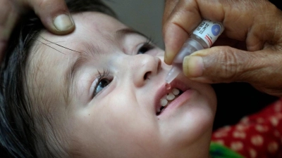 Ein Gesundheitshelfer verabreicht einem Kind einen Polio-Impfstoff. (Foto: K.M. Chaudary/AP/dpa)