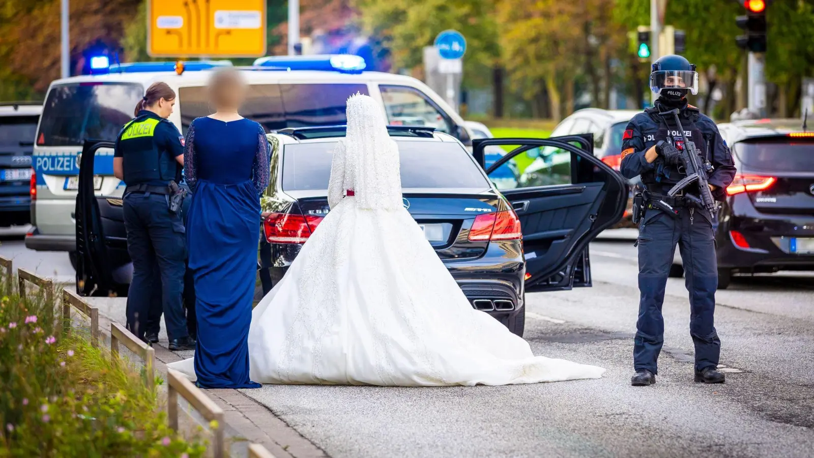 Polizisten kontrollieren Teilnehmer eines Hochzeitskorsos und ihre Fahrzeuge. (Foto: Moritz Frankenberg/dpa)