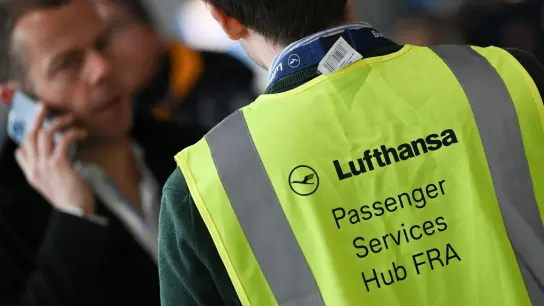 Ein Mitarbeiter der Lufthansa steht im Terminal 1 des Frankfurter Flughafens für Fragen von Fluggästen bereit. (Foto: Arne Dedert/dpa)