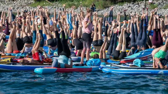 Yoga-Lehrerin Raphaela Schäufele leitet auf dem Bodensee eine Yogastunde auf Stand-up-Paddles. (Foto: Stefan Puchner/dpa)