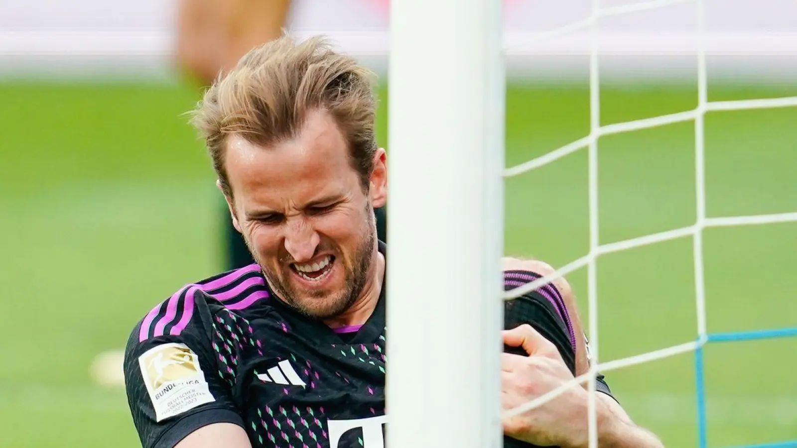 Harry Kane von München sitzt mit schmerzverzerrtem Gesicht auf dem Rasen. Er will gegen Dortmund spielen. (Foto: Uwe Anspach/dpa)