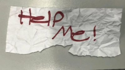 „Hilf mir“: Diese stück Papier hielt das Mädchen aus dem Auto hoch. (Foto: U.S. Department of Justice/AP/dpa)