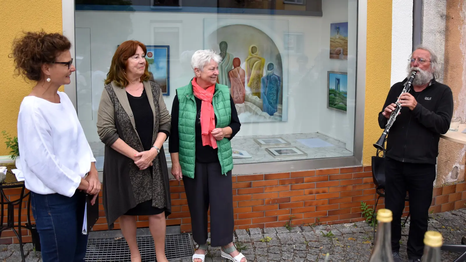 Bei der Eröffnung der Ausstellung in Herriedens Vorderer Gasse (von links): Bürgermeisterin Dorina Jechnerer, Künstlerin Brigitta Westphal und Mitorganisatorin Hanna Illig. Deocar Bösendörfer sorgte für den musikalischen Rahmen. (Foto: Werner Wenk)