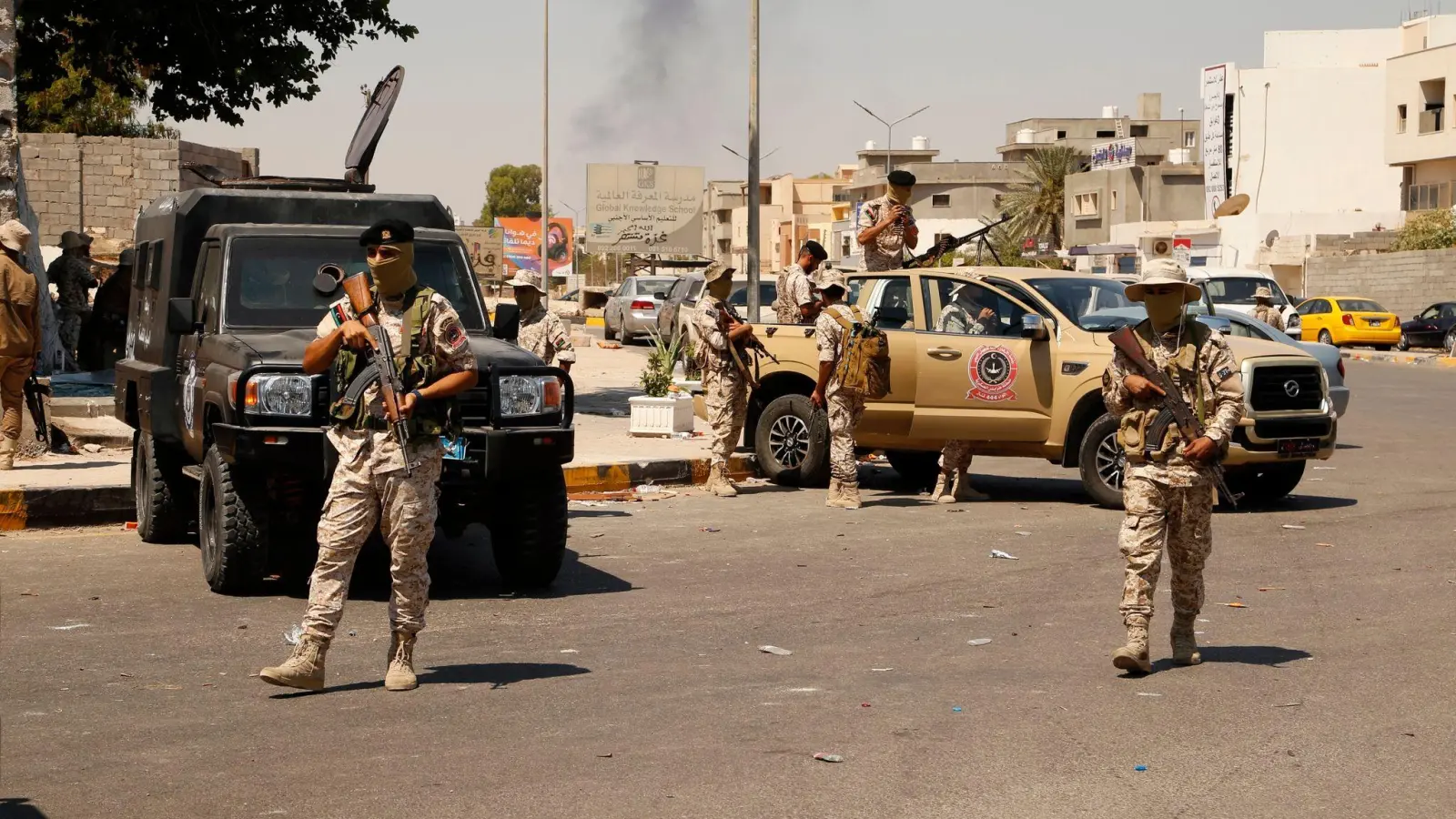 Vermummte Soldaten der libyschen Armee neben Militärfahrzeugen auf einer Straße in Tripolis. (Foto: Yousef Murad/AP/dpa)