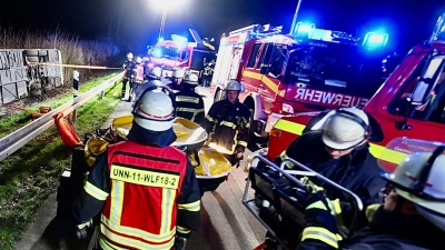 Einsatzkräfte der Feuerwehr arbeiten an einer Unfallstelle auf der Autobahn 44 (A44) an einem verunfallten Bus. (Foto: Daniel Schröder/dpa)