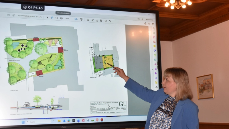 Claudia Wust zeigte einen Plan, wie man den Pausenhof gern umgestalten möchte. Die Skizze entwarf Landschaftsarchitektin Nicol Dießl. (Foto: Ute Niephaus)