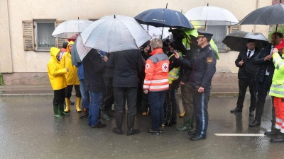 Markus Söder (verdeckt) steht, umringt von Journalisten, am Rande einer überfluteten Straße. (Foto: Karl-Josef Hildenbrand/dpa)
