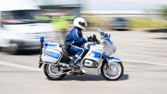 Ein Polizist fährt mit seinem Motorrad während einer Grenzkontrolle. (Foto: Robert Michael/dpa/Archivbild)