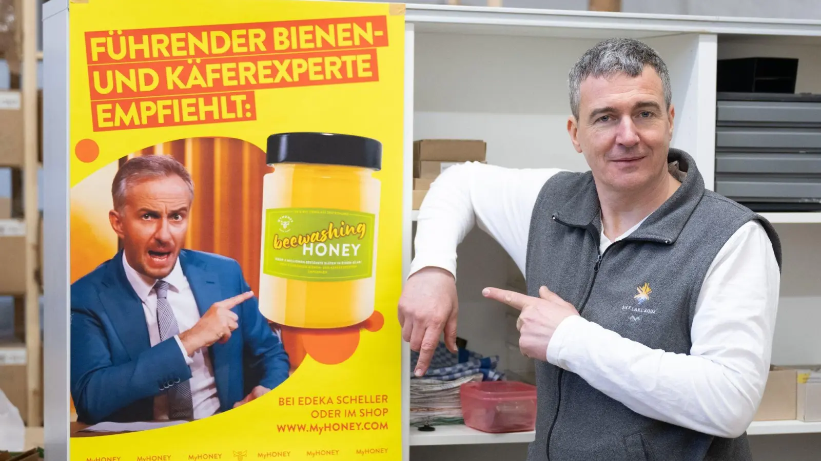 Imker Rico Heinzig neben einem Plakat mit dem Foto des Moderators Jan Böhmermann. (Foto: Sebastian Kahnert/dpa)