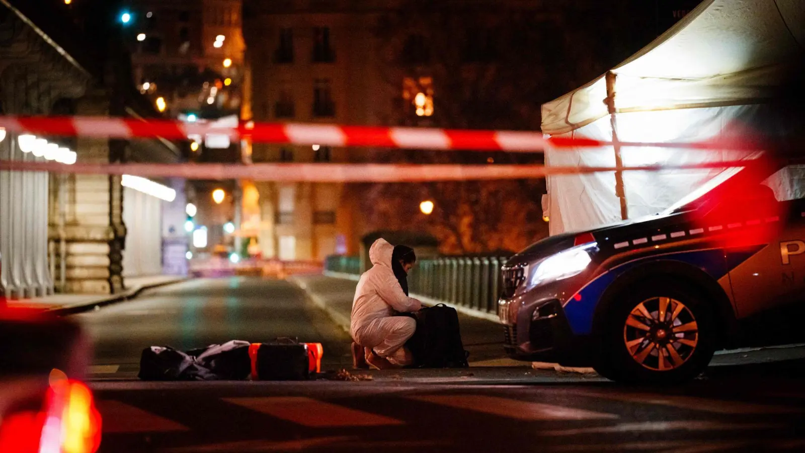 Ein Beamter der Kriminalpolizei arbeitet am Tatort unweit des Eiffelturms in Paris. (Foto: Dimitar Dilkoff/AFP/dpa)