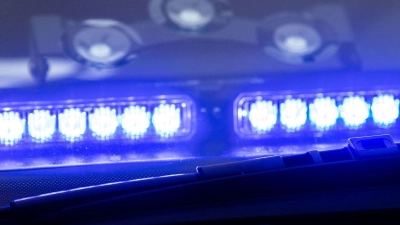 Ein Blaulicht leuchtet unter der Frontscheibe eines Einsatzfahrzeugs der Polizei. (Foto: Lino Mirgeler/dpa/Symbolbild)