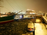 Das Kreuzfahrtschiff Iona (r) des britisch-amerikanischen Kreuzfahrtunternehmens P&amp;O Cruises fährt an den Hamburger Landungsbrücken über die mit kleinen Eisschollen bedeckte Elbe in Richtung eines Kreuzfahrtterminals in der Hafencity.  (Foto: Christian Charisius/dpa)