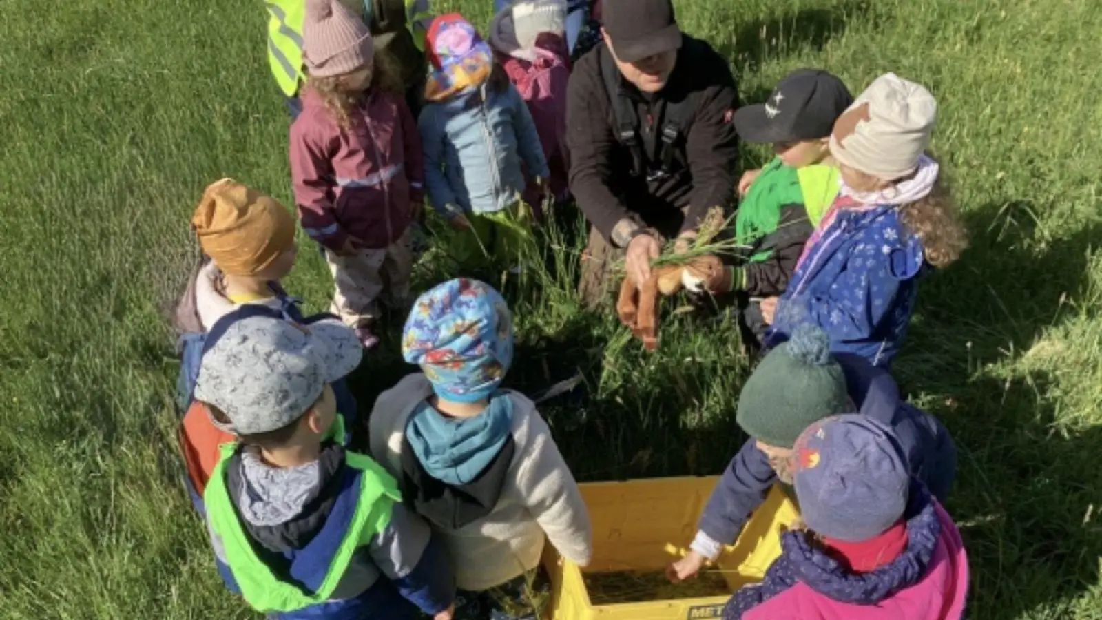 Bastian Pinsenschaum zeigt den Münchsteinacher Kindergartenkindern anhand eines Stofftieres, wie ein gerettetes Rehkitz aussieht – und was bei der Bergung zu beachten ist. (Foto: privat)