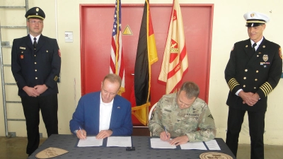 Colonel Michael Cookey und Oberbürgermeister Thomas Deffner unterzeichnen das Abkommen zur gegenseitigen Hilfeleistung. Hinten die Feuerwehr-Chefs Steffen Beck (links) und Stefan Grötschel. (Foto: Winfried Vennemann)