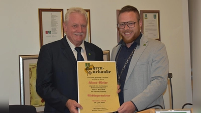 Neustadts Bürgermeister Alexander Müller (rechts) überreichte seinem Vorgänger Klaus Meier die Ehrenurkunde, die ihn als Altbürgermeister ausweist. Dieser freute sich über den Ehrentitel. (Foto: Ute Niephaus)