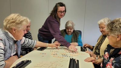 Christine Tanch (stehend) gehört zum ehrenamtlichen Team des TagesTreffs und unterstützt manchmal beim Spielen. (Foto: Nina Daebel)