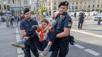 Polizisten tragen auf der Kreuzung am Stachus in der Münchener Innenstadt Aktivisten der Letzten Generation weg. Ihre Aktionen werden teilweise verboten. (Foto: Peter Kneffel/dpa)
