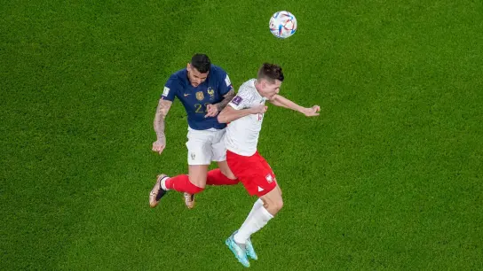 Polens Jakub Kaminski (r) kämpft im WM-Achtelfinale mit Frankreichs Theo Hernandez um den Ball. (Foto: Thanassis Stavrakis/AP/dpa)