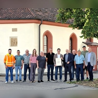 Wassertrüdingens Bürgermeister Jörg Edelmann (Mitte, mit Urkunde) freut sich gemeinsam mit Ingo Steinbrecher (Abteilungsleiter am Amt für Ländliche Entwicklung Mittelfranken, rechts daneben) und Projektleiter Jens Schulze (rechts) über den offiziellen Startschuss zur Dorferneuerung. Mit dabei waren auch engagierte Anwohner und Mitglieder der Arbeitskreise. (Foto: ALE/Diane Mayer)