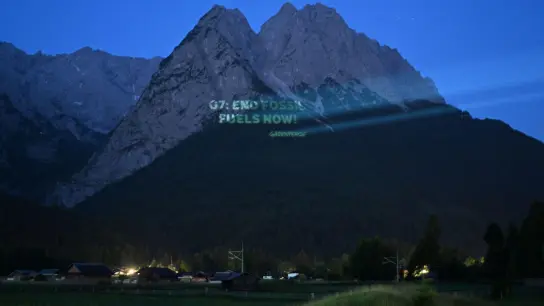 An die Waxensteine projiziert Greenpeace in den frühen Morgenstunden “G7: End Fossil Fuels Now”. (Foto: Angelika Warmuth/dpa)