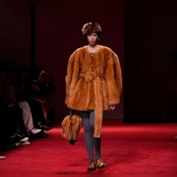 Voluminös und warm: Jacken sind in diesem Winter wahre Blickfänger. Ein opulentes Beispiel: die bernsteinfarbene Jacke mit Gürtel und strukturiertem Kunstfell aus der Bottega Veneta Herbst/Winter 2026-2027 Damenkollektion. (Foto: Luca Bruno/AP/dpa-tmn)