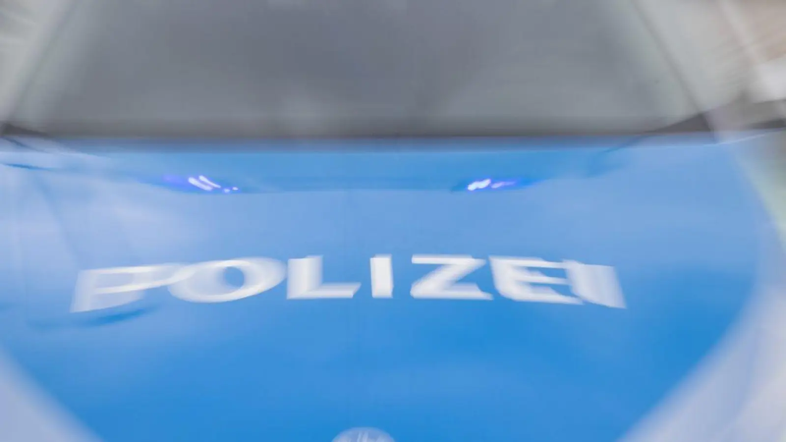 Ein Streifenwagen der Polizei mit eingeschaltetem Blaulicht. (Foto: Daniel Karmann/dpa/Symbolbild)