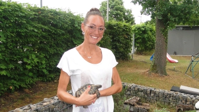 Pension für gepanzerte Gäste: Linda Carl steht mit Fund-Schildkröte Ali auf dem Arm im selbstgebauten Gehege. (Foto: Winfried Vennemann)