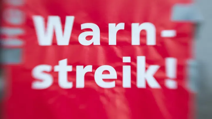 „Warnstreik!“ steht auf einem Schild. (Foto: Friso Gentsch/dpa/Symbolbild)