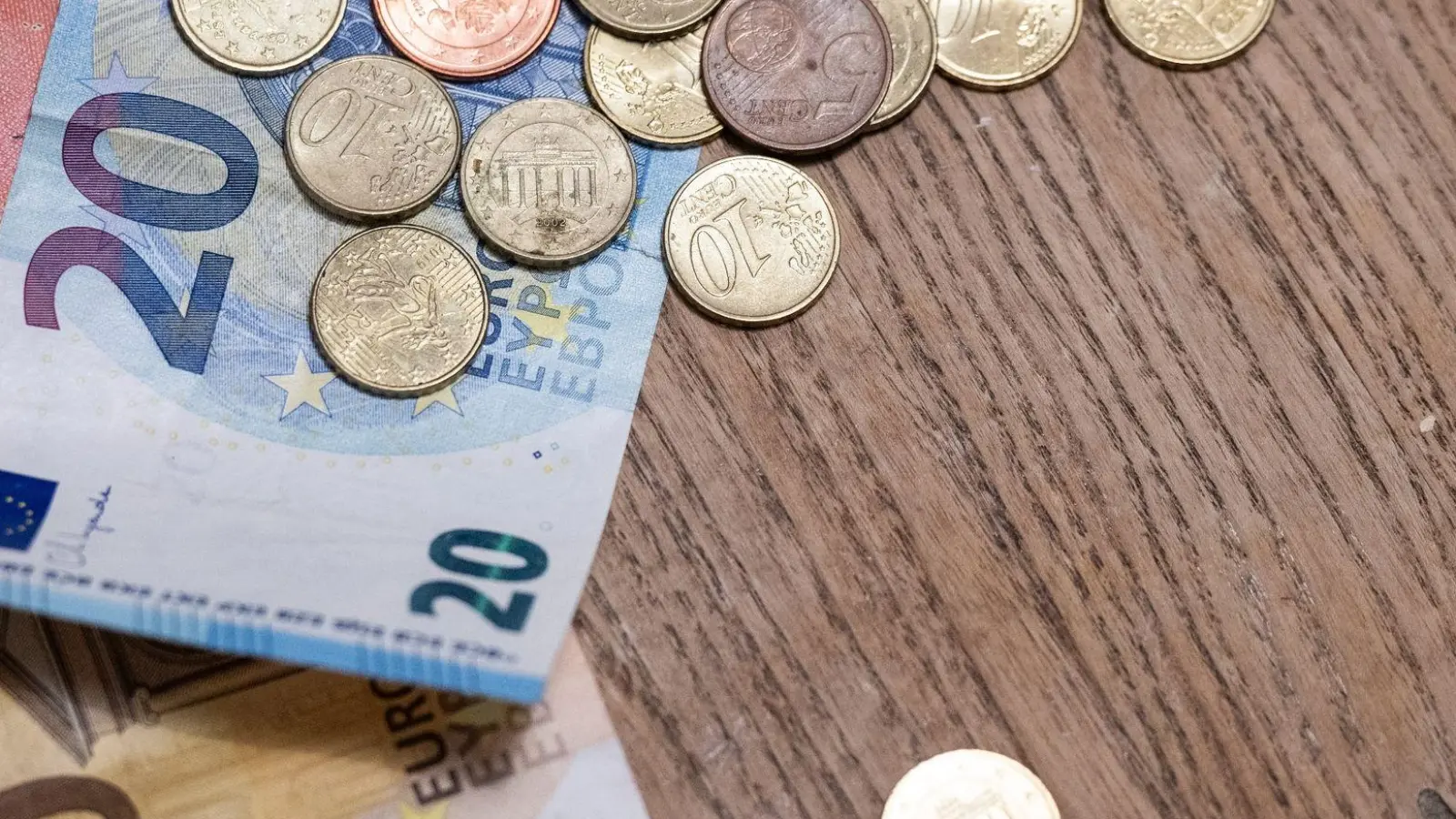 Geldscheine und Münzen liegen auf einem Tisch. (Foto: Hannes P Albert/dpa/Symbolbild)