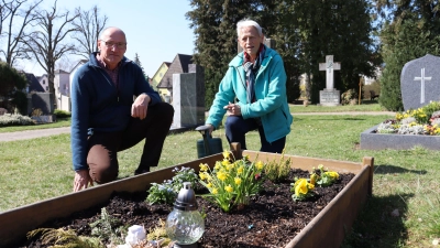 Wie auch die meisten anderen, ist das Grab des jungen Mannes schon für den Frühling bepflanzt: Michael Rackl und Waltraud Löhe kümmern sich darum. (Foto: Antonia Müller)