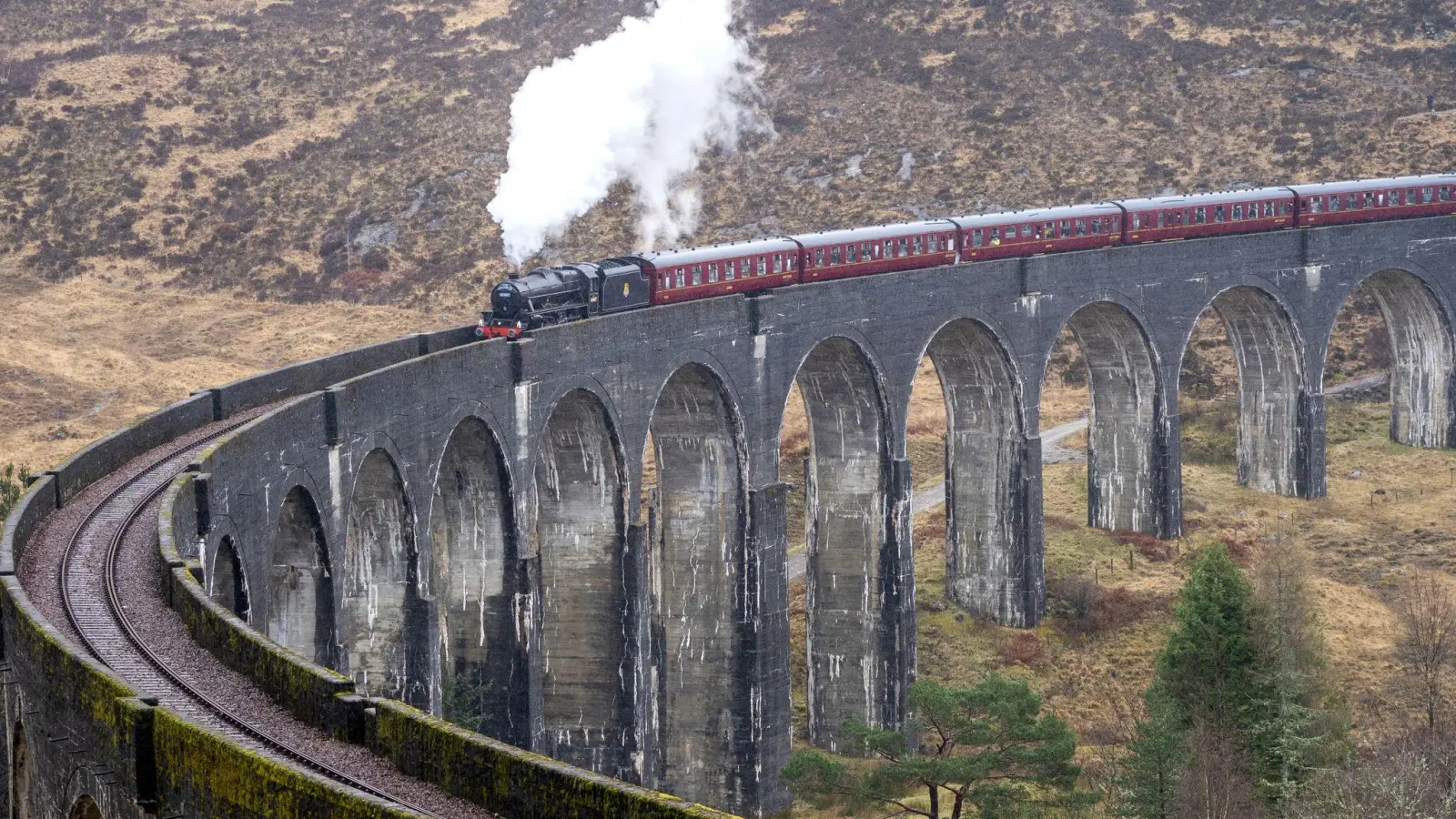 Der erste Jacobite Express der Saison 2022 überquert das Glenfinnan-Viadukt auf seinem Weg von Fort William nach Mallaig. Die „Harry Potter“-Filme machten die Zugstrecke über das Glenfinnan-Viadukt in Schottland weltberühmt. (Foto: Jane Barlow/PA Archive/dpa)