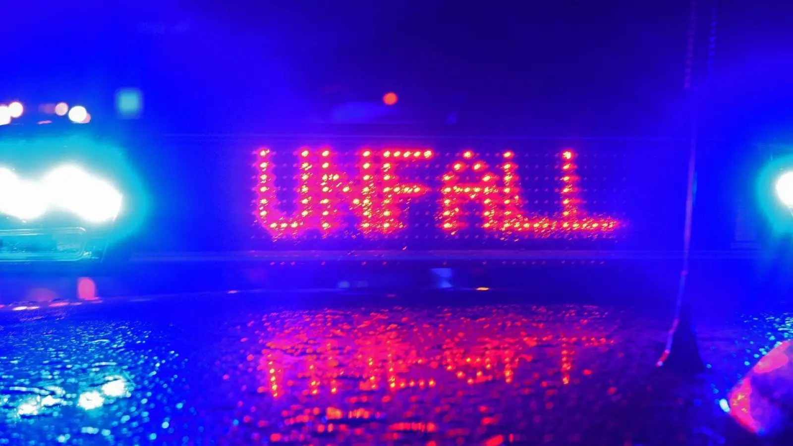 „Unfall“ in LED-Leuchtbuchstaben steht zwischen zwei Blaulichtern auf dem Dach eines Polizeiwagens. (Foto: Stefan Puchner/dpa/Symbolbild)