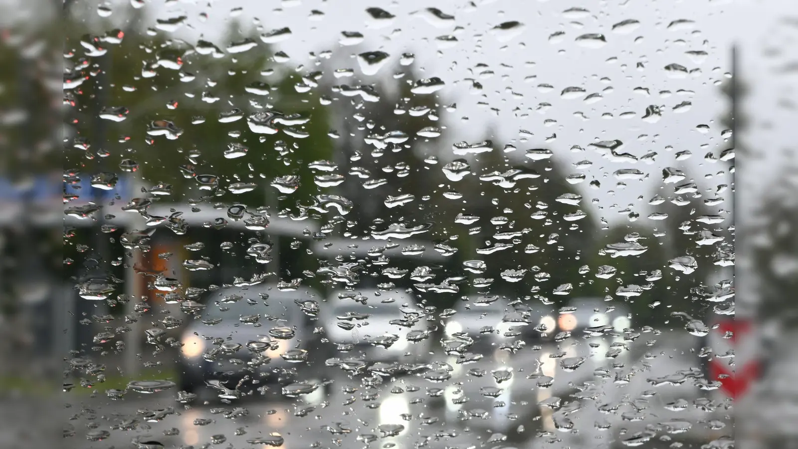 Regentropfen sammeln sich auf einer Scheibe. (Foto: Bernd Weißbrod/dpa/Symbolbild)