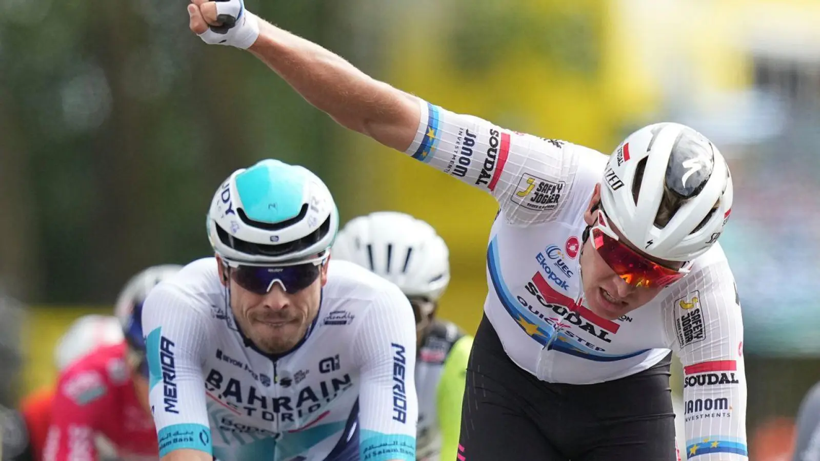 Tim Merlier feiert den Etappensieg, der deutsche Sprinter Phil Bauhaus (L.) freut sich über den dritten Rang.  (Foto: Thibault Camus/AP/dpa)