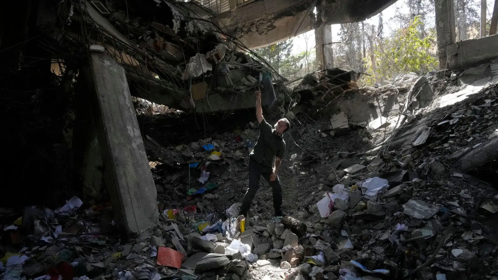 Ein Mann zeigt auf Schäden im Bürogebäude des Ewin-Gefängnisses in der iranischen Hauptstadt.  (Foto: Vahid Salemi/AP/dpa)