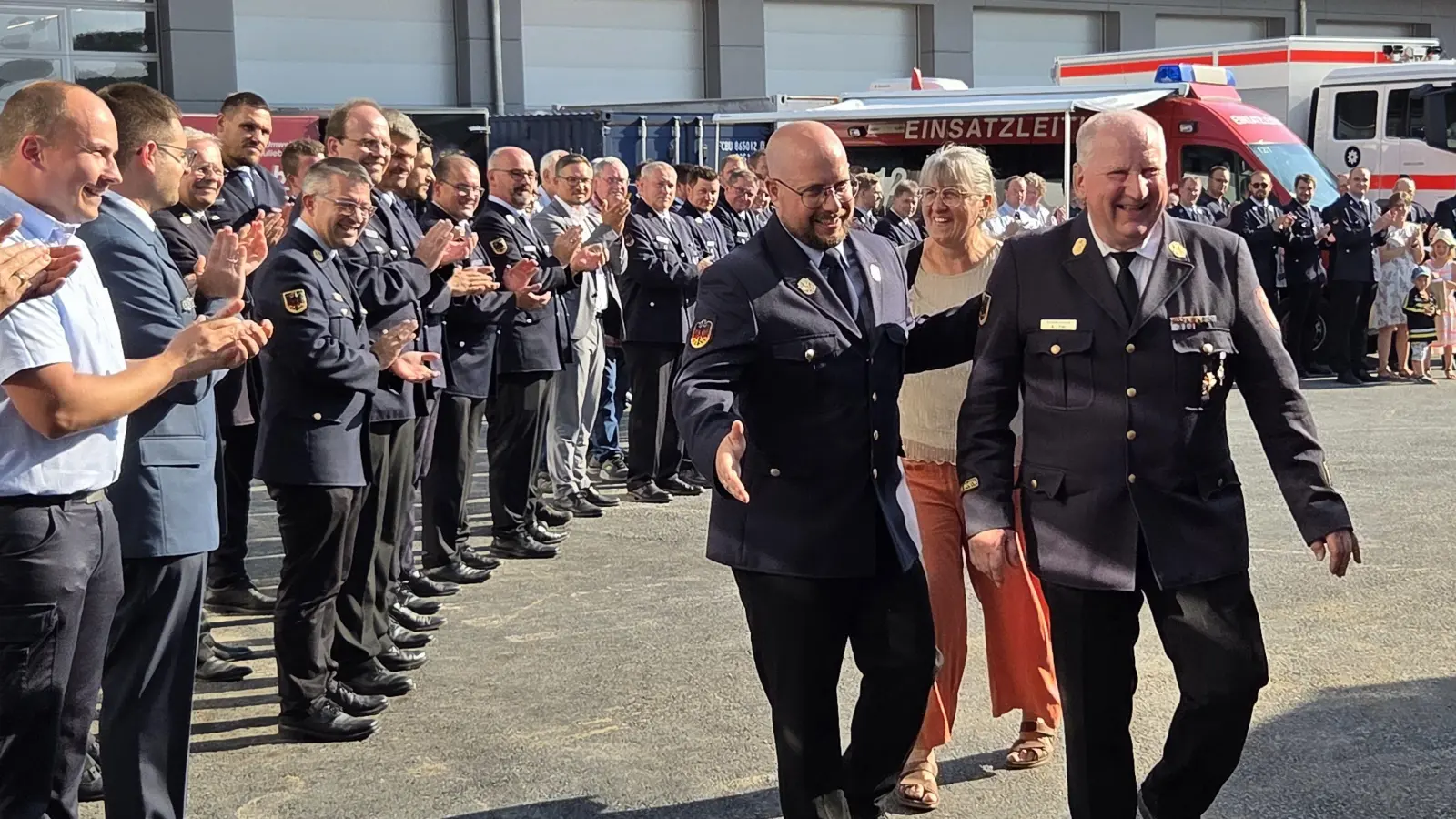 Alfred Tilz und seine Frau Brigitte wurden vom neuen Kreisbrandrat Florian Brandt (von rechts) durch ein Spalier von Feuerwehrführungskräften, Kommandanten und weiteren Honoratioren zur offiziellen Verabschiedung geleitet. (Foto: Rainer Weiskirchen)