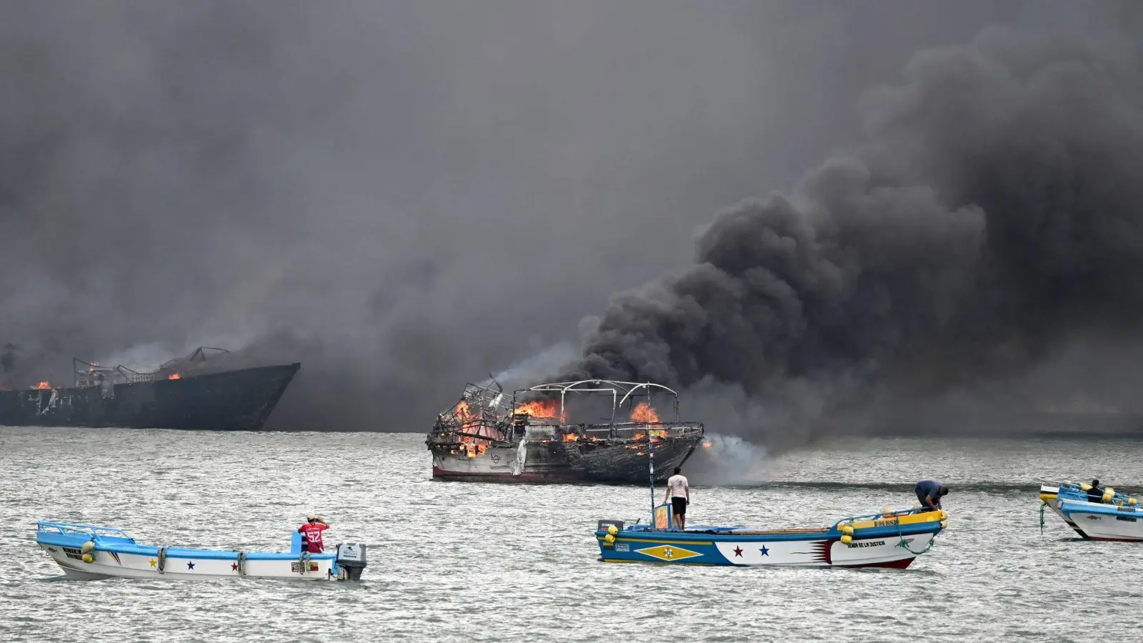 Im Hafen von Manta stehen mehrere Fischerboote in Flammen. (Foto: Ariel Ochoa/AP/dpa)