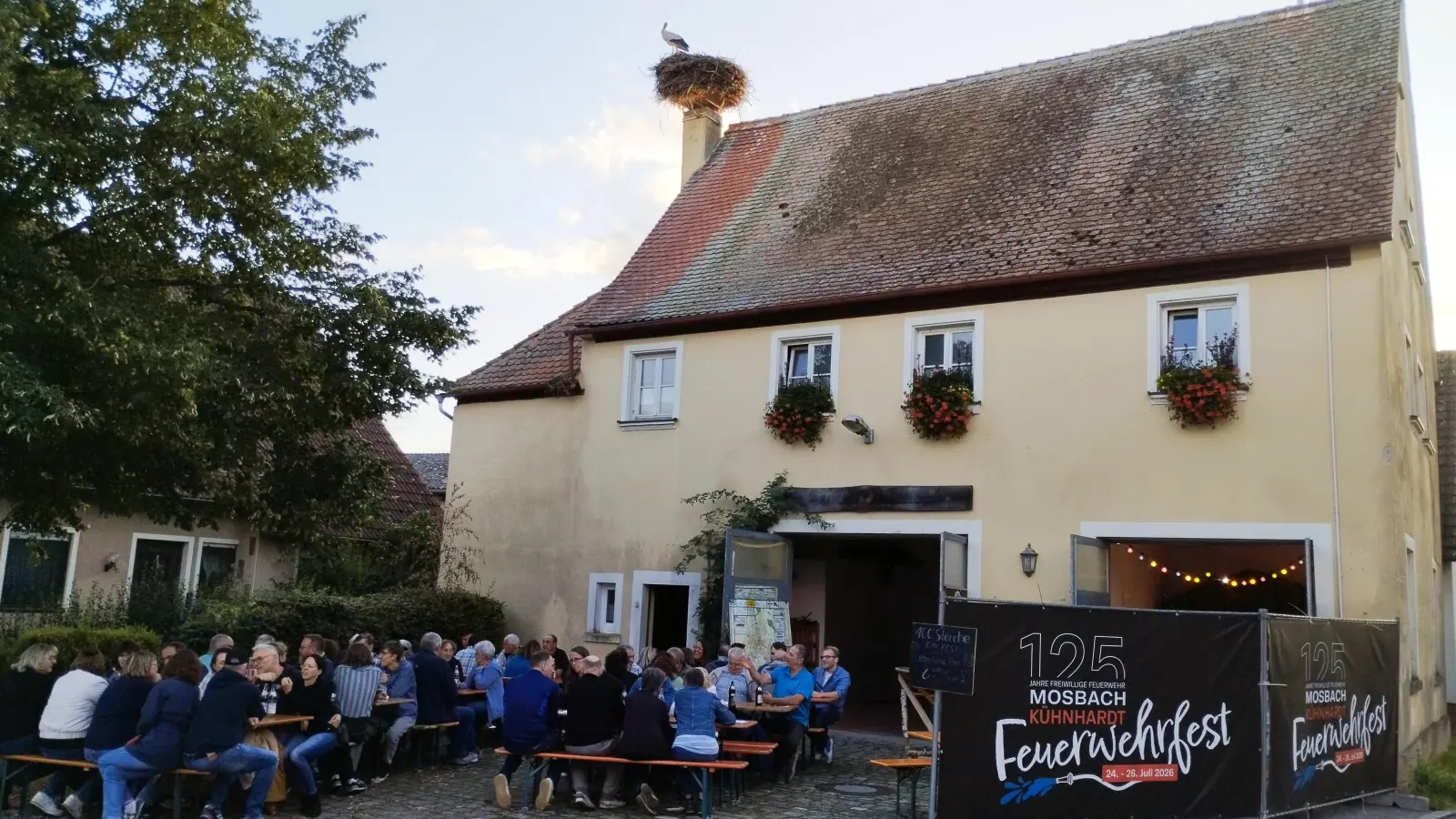 Unter den neugierigen Blicken eines Altstorches feierten die Einwohnerinnen und Einwohner der ehemaligen Gemeinde Mosbach, dass in diesem Jahr der 100. Storch in dem heutigen Feuchtwanger Ortsteil beringt worden ist. (Foto: FFW Mosbach)